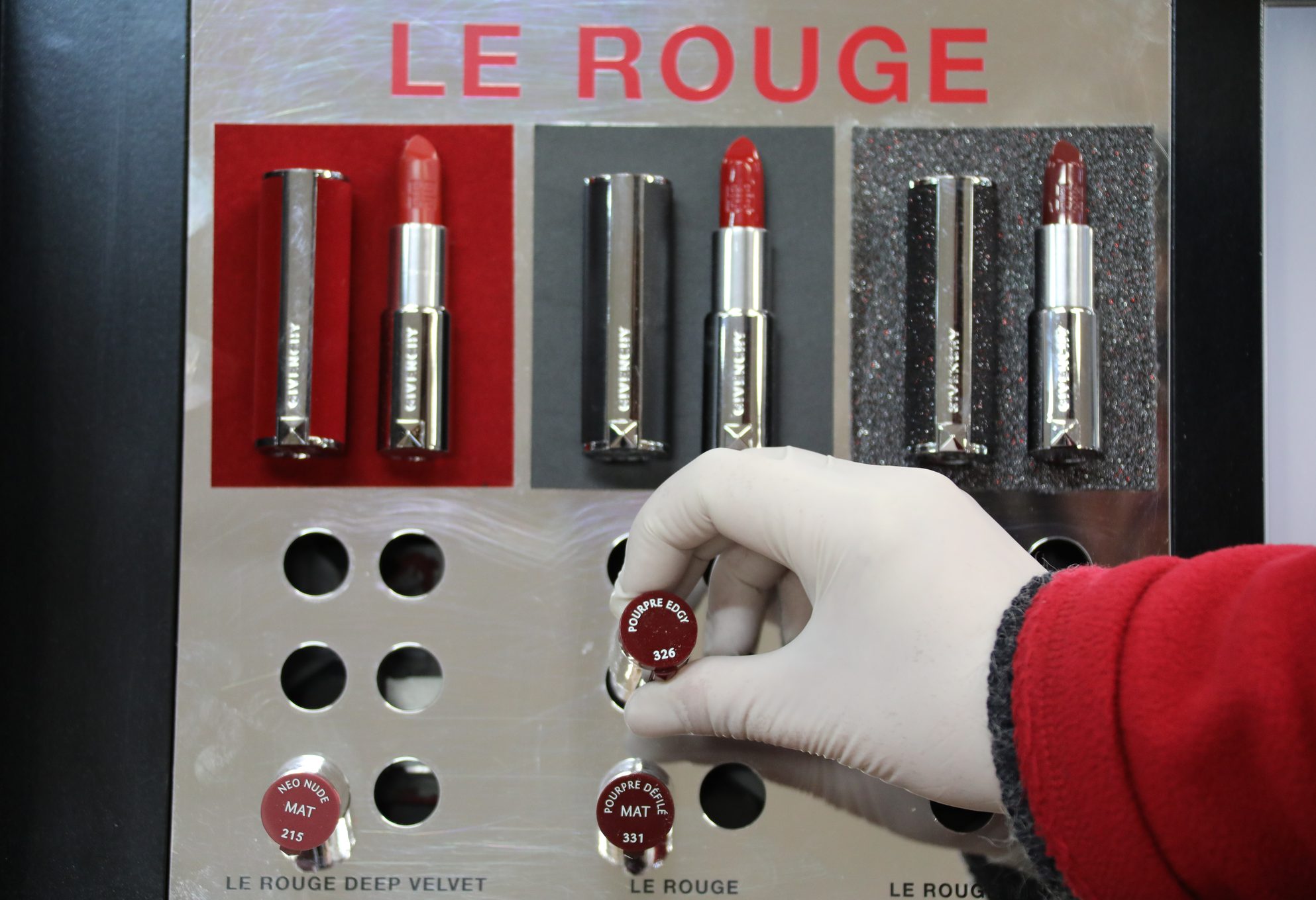 Réassort d'un présentoir de rouges à lèvres en parfumerie